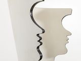 a white vase with a face cut out of it