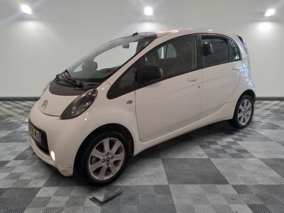 une petite voiture blanche garée dans une pièce