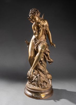 a bronze statue of a woman holding a bird on a pedestal