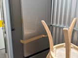 une photo montrant un réfrigérateur et une chaise dans une pièce
