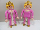 two figurines of a woman and a man dressed in pink