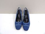 pair of blue shoes on a white surface with a wall in the background