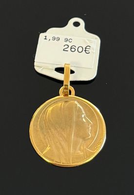 médaillon plaqué or représentant la tête d'une femme, muni d'une plaque portant un nom