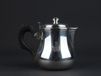 an antique silver coffee pot on a black background