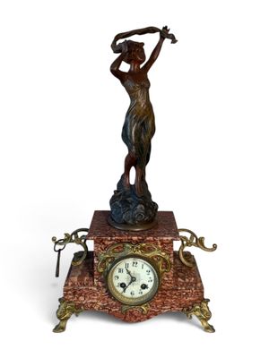 statue d'une femme tenant un club de golf au sommet d'une horloge