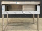 a stainless steel table with a drawer underneath it
