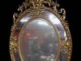 un miroir au cadre doré accroché à un mur noir