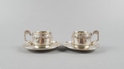 une paire de tasses à thé et de soucoupes en métal argenté
