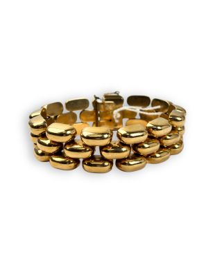 a close up of a gold bracelet on a white background