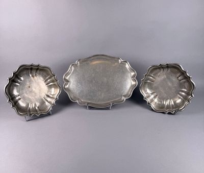 three silver trays on a table with a silver background