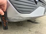 a person measuring the width of a car with a ruler