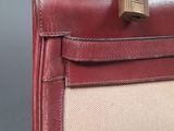 the back of a red and beige purse with a padlock on it