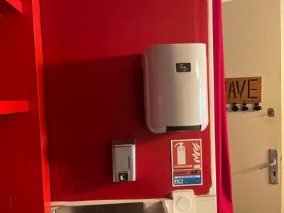 a picture of a red bathroom with a white toilet and a red shower curtain