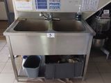 a sink and a trash can in the kitchen