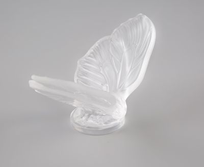 une sculpture en verre représentant un oiseau sur un fond blanc