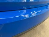 a close up of a blue car ' s bumper with a sticker on it