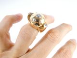 a person ' s hand holding a gold and diamond ring