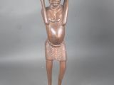 statue d'un homme coiffé d'un chapeau et tenant un morceau de bois