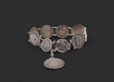 un bracelet en argent orné de pièces et d'une breloque en forme de pièce