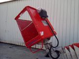 a red machine that is sitting next to a building