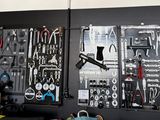 many different tools hanging on the wall in this garage