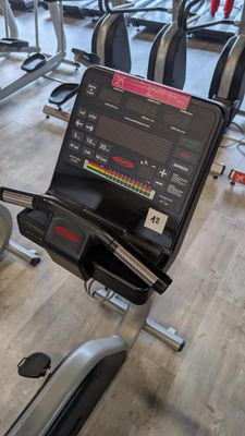 a gym room with tread machines and a monitor on the wall