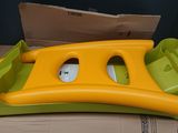 a yellow and green plastic toy boat on a cardboard box