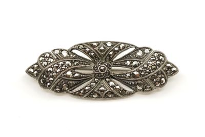 une broche ancienne en argent, ornée de filigranes sur fond blanc