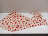pink and red cherry print dress on a white table