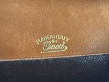 a close up of a brown and black purse with a gold logo