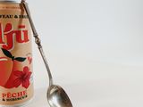 a can of fruit juice with a spoon in it
