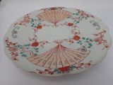 une assiette blanche ornée de motifs rouges et verts