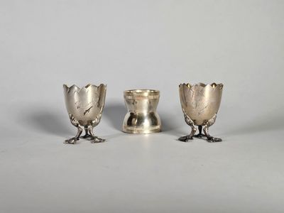 un ensemble de trois vases en argent posés sur une table