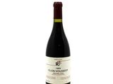 the bottle of red wine is sitting on a white surface