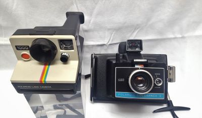 deux appareils photo Polaroid posés côte à côte sur une table