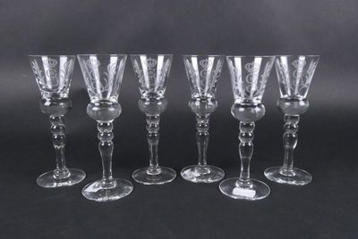 six verres à vin transparents alignés sur un fond noir