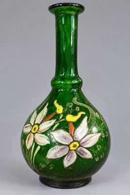 un vase en verre vert orné de fleurs peintes