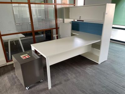 a desk with a chair and a cabinet in an office