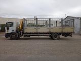 a truck with a cage on the back parked in a parking lot