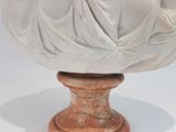 a statue of a woman sitting on top of a vase