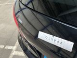 a sticker on the back of a car that is parked in a parking lot