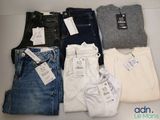 plusieurs paires de jeans sont disposées sur une table