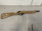 un fusil posé par terre près d'un mur