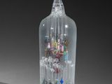 une bouteille en verre contenant de nombreux petits objets en verre