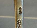 a silver spoon with a silver handle on a table