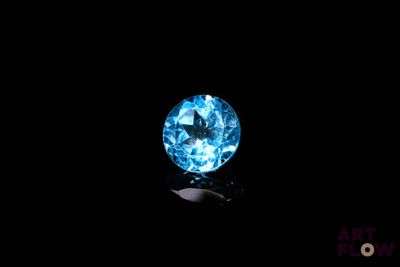 gros plan d'un diamant bleu sur une surface noire