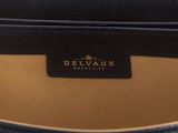 the inside of a black leather bag with a gold logo on it