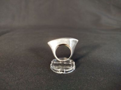 sterling silver ring on clear acrylic stand on black cloth