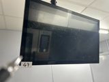 a flat screen tv hanging from a ceiling in a room