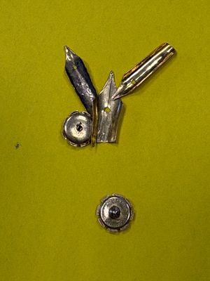 une photo représentant un couteau et quelques vis posés sur une surface verte